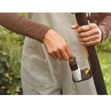 Batteridriven grästrimmer med laddare i bruk