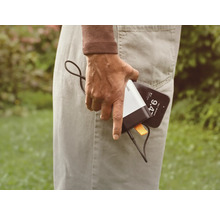 En person håller i en mobiltelefon och en powerbank.