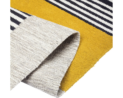 Detaljvy av en matta med randigt mönster och rullad kant