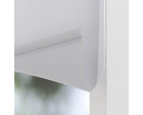 Detaljvy av en vit rullgardin vid fönstret