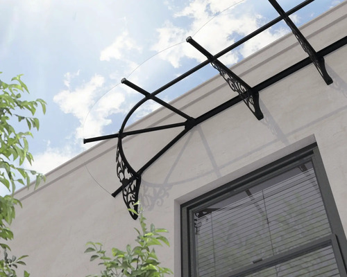 Entrétak med transparent tak och dekorativa svarta metallfästen ovanför ett fönster.