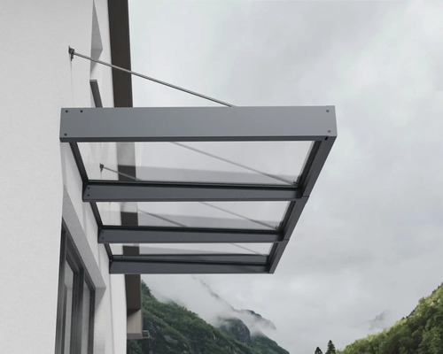 Modern entrétak av glas med antracitgrå aluminiumram, monterat på en yttervägg med dragstänger.