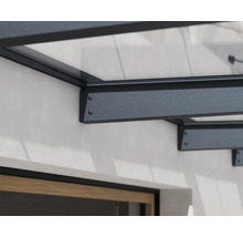 Detalj av väggfästet för ett skärmtak av aluminium och glas.