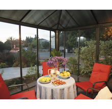 Övertäckt sittgrupp med bord, blommor och röda möbler