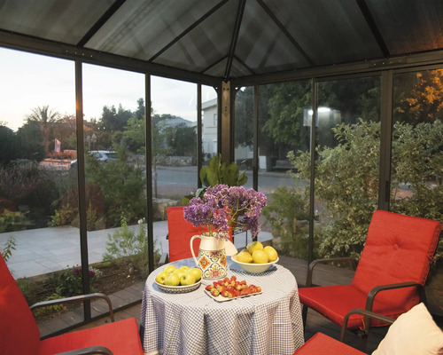 Övertäckt sittgrupp med bord, blommor och röda möbler