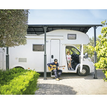 Husbil under en carport med lekande barn