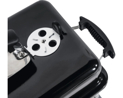 Detaljvy av en kolgrill med ventilationsspjäll och handtag