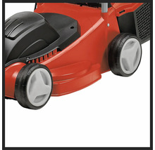 Detaljvy av en röd gräsklippare med svarta och vita element.