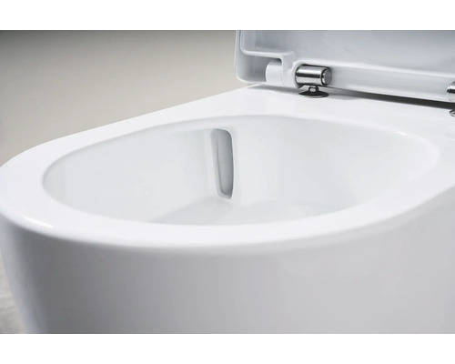 Detaljvy av en spolkantfri toalett med öppet toalettlock.