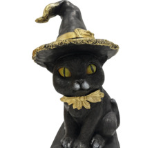 Dekorativ svart kattfigur med häxhatt och halsband som halloween dekoration