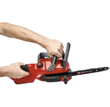 Einhell batteridriven motorsåg hålls med två händer i handtagen.