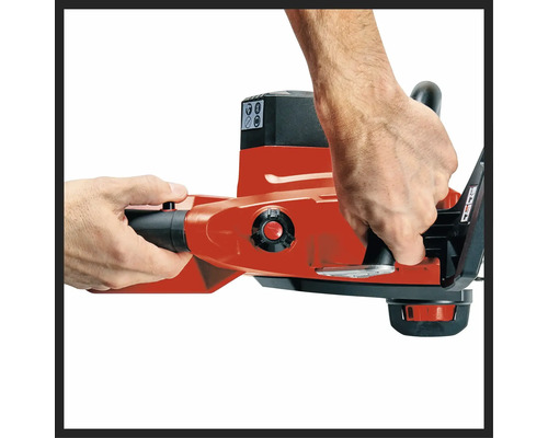 Närbild på händer som håller en motorsåg stadigt i de ergonomiska handtagen.