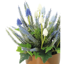 Konstgjord blomsterarrangemang med blå och vita blommor i kruka