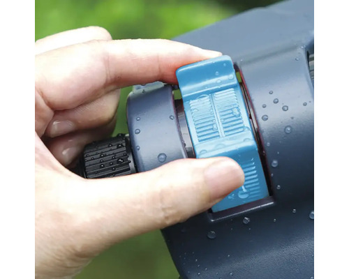 Handen justerar sprinkler för trädgårdsbevattning