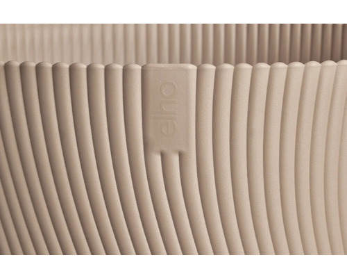 Detaljvy av en blomkruka i plast med vertikalt räfflad struktur och Elho Logo.