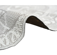 Närbild på en slätvävd matta med fokus på textur och den kantade kanten.