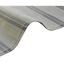 Närbild på en vävd grå syntetisk matta med förstärkt kant.