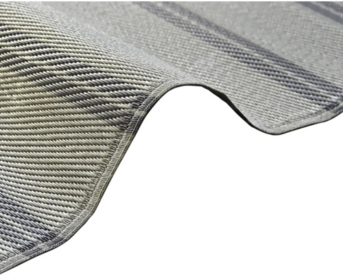 Närbild på en vävd grå syntetisk matta med förstärkt kant.