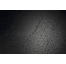 Detaljvy av en mörk golvyta med träådring och synlig kvist.