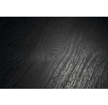 Närbild av en mörk golvyta med trästruktur, synliga ådringar och kvistar.