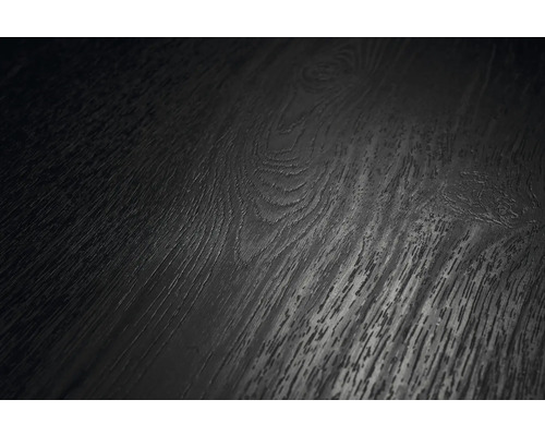 Närbild av en mörk golvyta med trästruktur, synliga ådringar och kvistar.