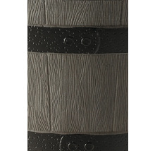 Detaljbild av en regntunna i träimitation med horisontella band och nitar.