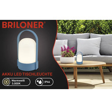 Briloner Logo, batteridriven LED-bordslampa för utomhusbruk, varmvitt ljus 3000 Kelvin, IP44 stänkskydd, bärbar lampa med handtag på ett trädgårdsbord.