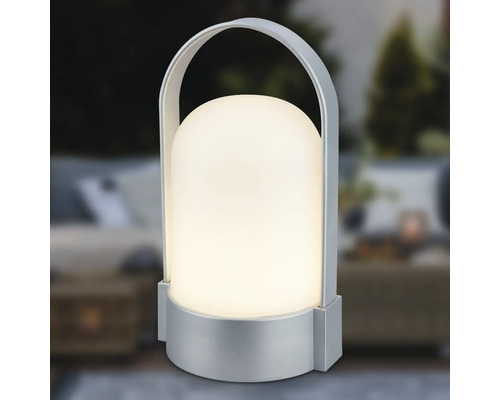 Bärbar LED-bordslampa med silverfärgad fot och bygelhandtag, kupolformad skärm, varmvitt ljus.