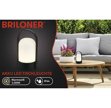 Briloner Logo, svart uppladdningsbar LED-bordslampa på ett trädgårdsbord i trä, varmvitt ljus 3.000 Kelvin, kapslingsklass IP44.