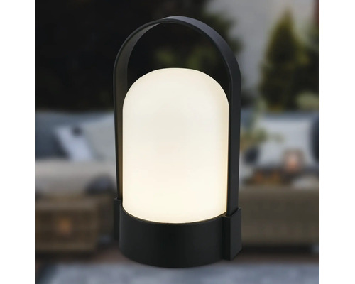 Modern bärbar utomhuslampa med svart hölje, handtag och varmvitt ljus.