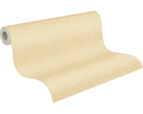 Beige nonwoventapet med fin struktur på rulle.