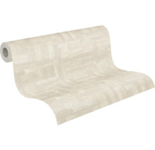 Delvis utrullad non-woven tapet med fin textur och ett diskret geometriskt mönster i ljusbeige.