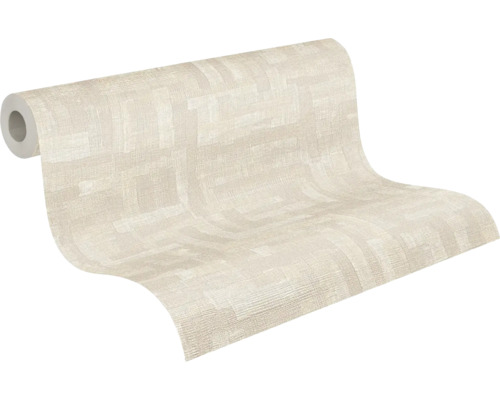 Delvis utrullad non-woven tapet med fin textur och ett diskret geometriskt mönster i ljusbeige.