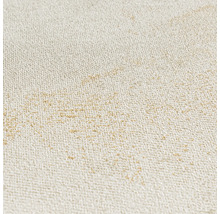 Detaljbild av en strukturerad non-woven tapet med fina guldfärgade accenter.