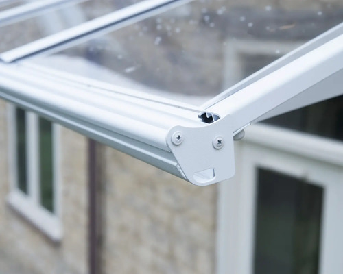 Detalj av ett vitt altantak i aluminium med transparenta paneler.