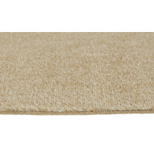 Närbild av en mjuk beige heltäckningsmatta med en synlig kant.
