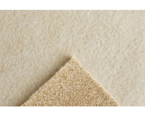 Mjuk heltäckningsmatta eller fleecematerial med texturerad yta och ett vikt hörn som visar baksidan.