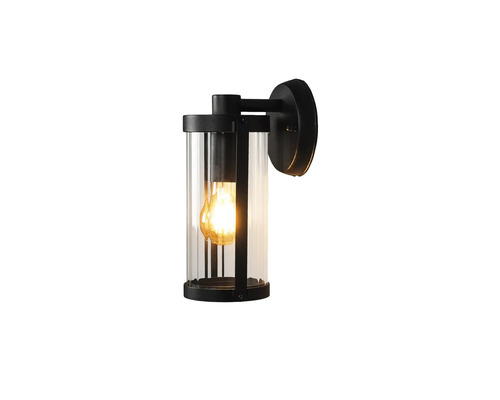 Modern utomhusvägglampa i cylindrisk form av svart metall och klart glas med tänd ljuskälla.