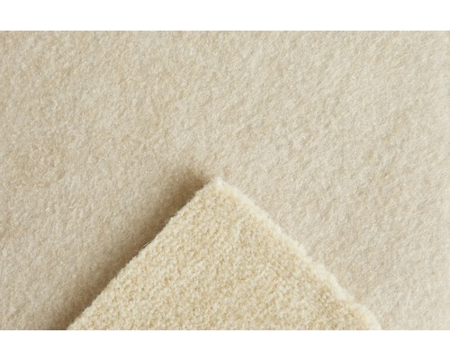 Närbild på strukturen hos en beige nålfiltsmatta med ett uppvikt hörn.