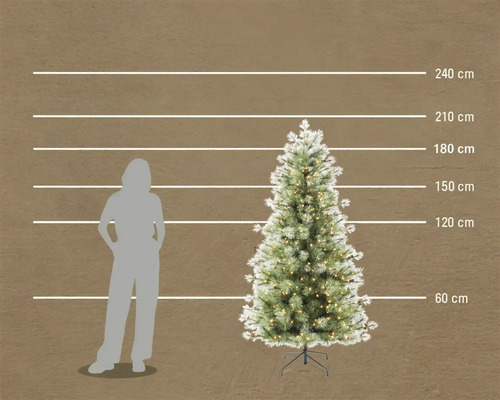 Konstgjord julgran med belysning och snöeffekt, höjd 210 centimeter i jämförelse med en person.