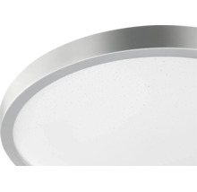 Rund LED-taklampa med silverfärgad metallram och vit diffusor med stjärnhimmelseffekt.