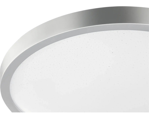 Rund LED-taklampa med silverfärgad metallram och vit diffusor med stjärnhimmelseffekt.