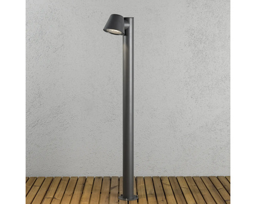Modern pollare i metall för utomhusbruk, cylindrisk design med lutande lamphuvud, monterad på en träterrass.