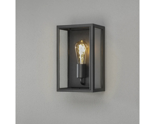 Rektangulär vägglampa med svart ram, glasrutor och en dekorativ ljuskälla.