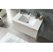 Modern vägghängd kommod med vitt tvättställ, beige underskåp och kromad blandare i ett ljust badrum.