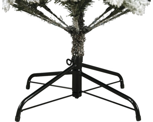 Detaljbild av en svart julgransfot i metall med fyra ben och en låsskruv för en snötäckt julgran.