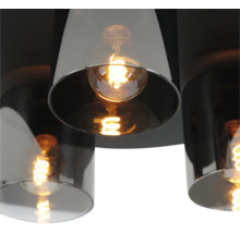 Modern taklampa med cylindriska skärmar i rökglas och tända filamentlampor.