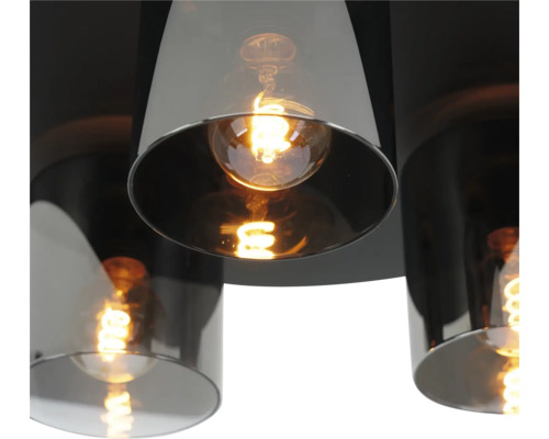 Modern taklampa med cylindriska skärmar i rökglas och tända filamentlampor.