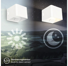 Vägglampa med skymningssensor visas i två lägen under dag och natt