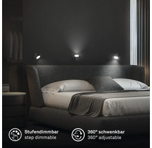 Tre vridbara och stegvis dimbara väggspotlights i ett modernt sovrum ovanför en stoppad dubbelsäng.